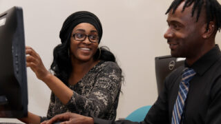 Three students study on laptops