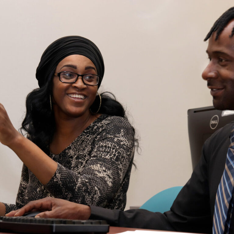 Three students study on laptops