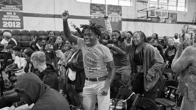 Black and white photo of students excited on campus