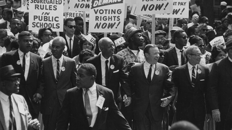Leaders of the Civil Rights Movement march with signs